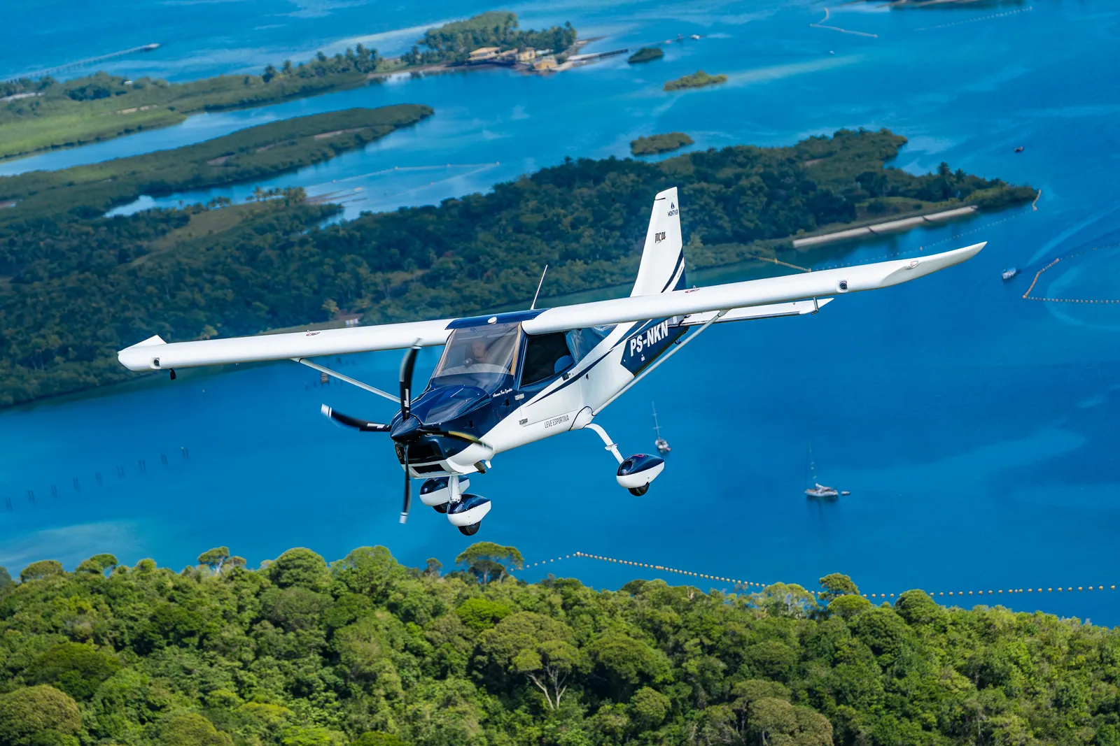 MC01 Fast PS-NKN em voo sobre ilhas e mar azul